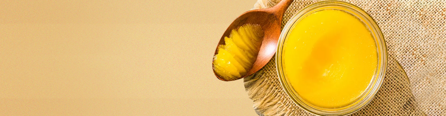 A jar of rich, golden Bembie's Grass-Fed Ghee with a wooden spoon on a rustic burlap surface, showcasing its smooth texture and high quality for cooking and baking.